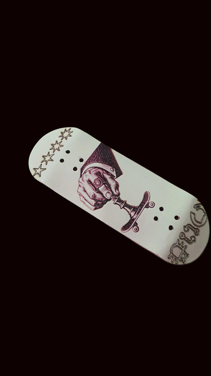 White fingerboard deck with purple boxing-hand graphic and stars along the top edge