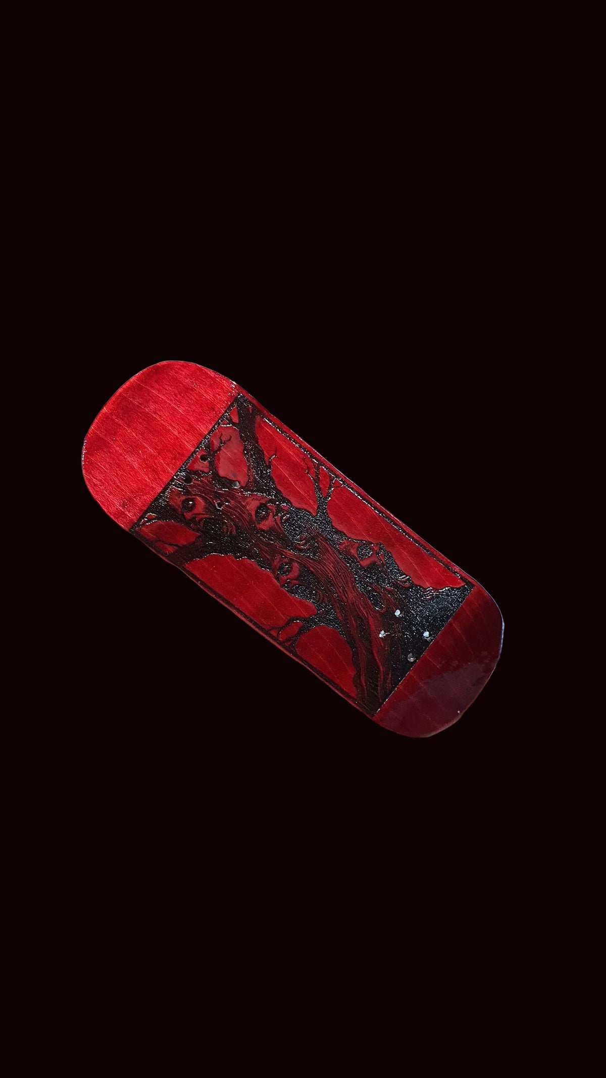 Red fingerboard deck at an angle, deer face graphic across the top