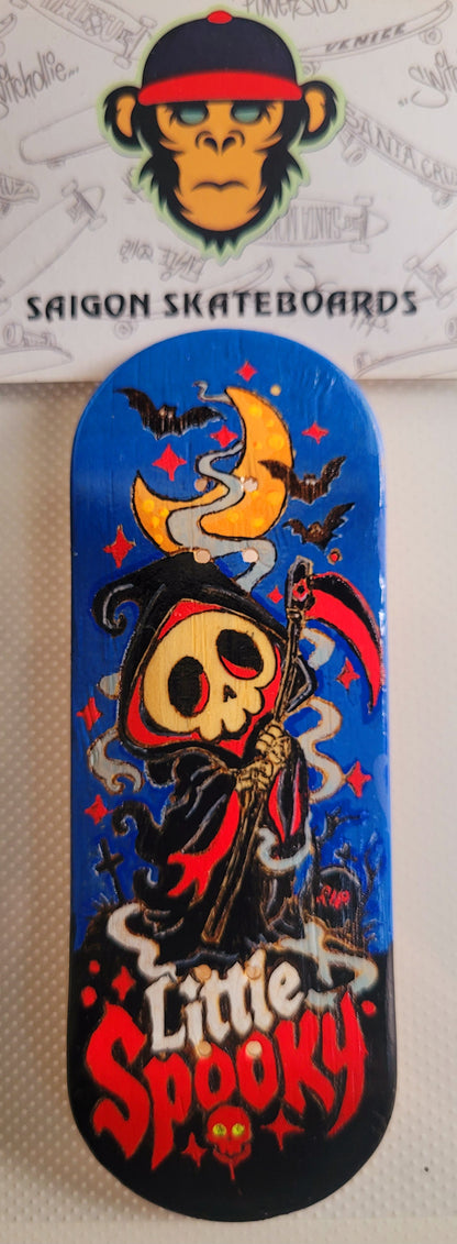 Blue fingerboard deck with skull witch graphic and red "Little Spooky" text