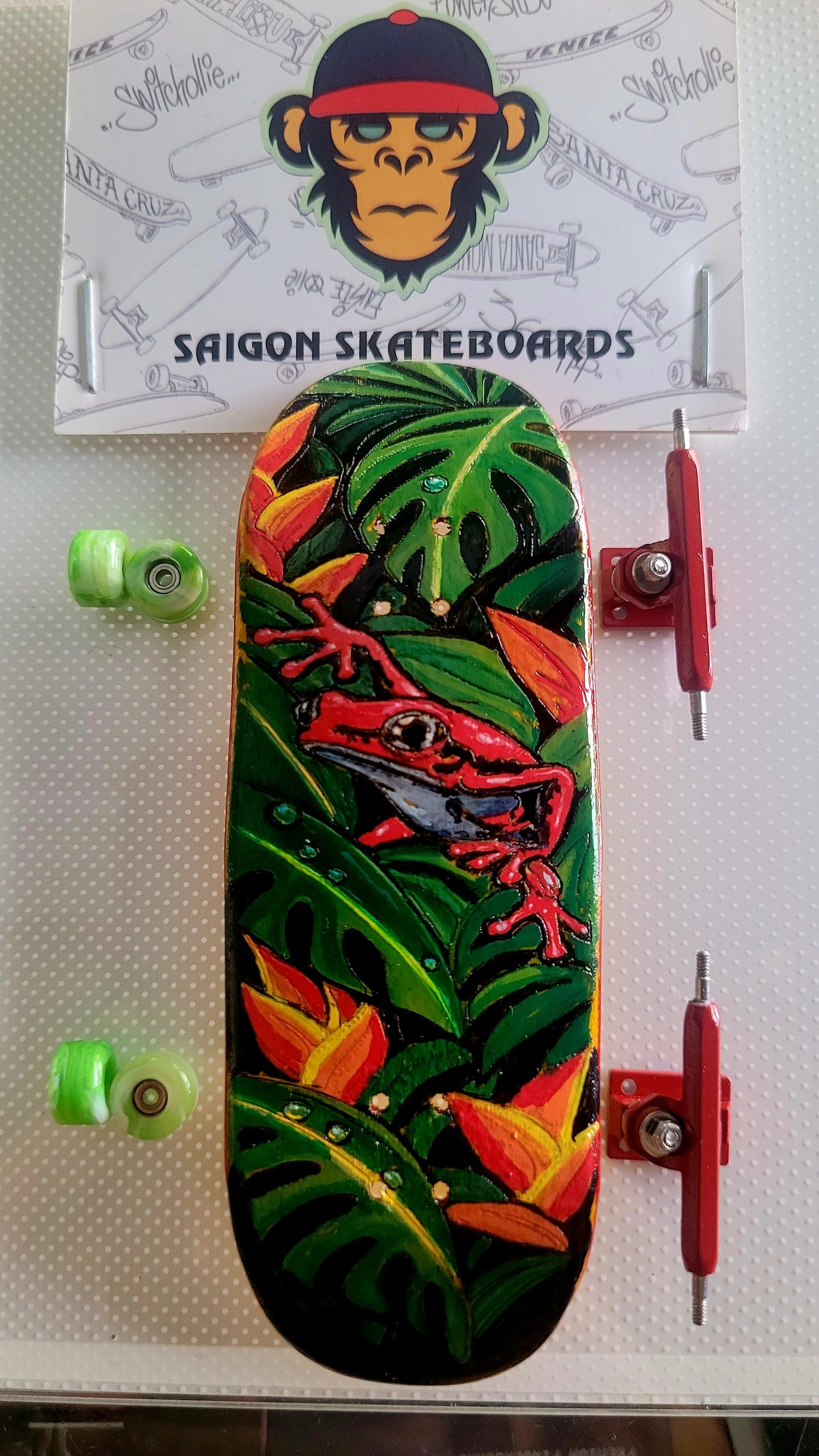 Green jungle fingerboard deck with red lizard graphic and lime green wheels