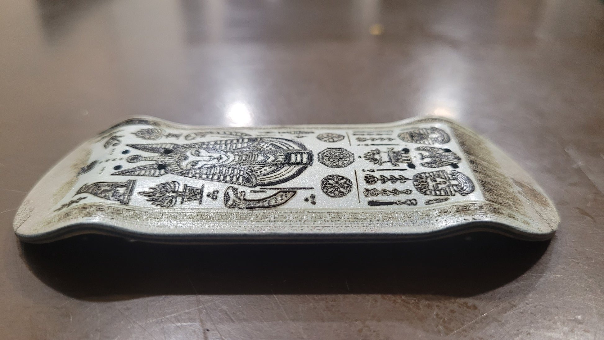 Decorative stone with intricate carvings on a wooden surface