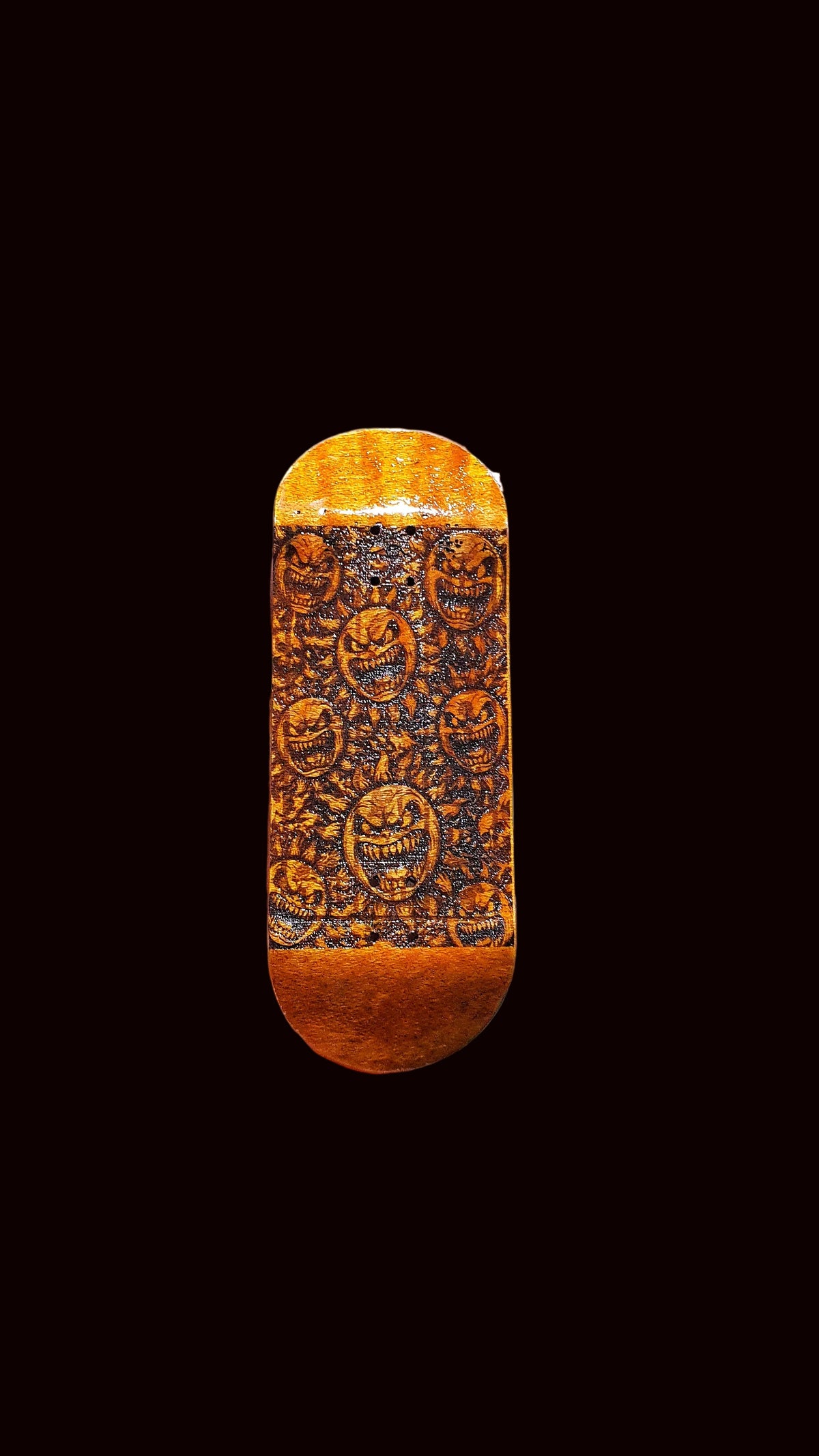 Fingerboard deck end view, orange stained wood with dark ornate face pattern