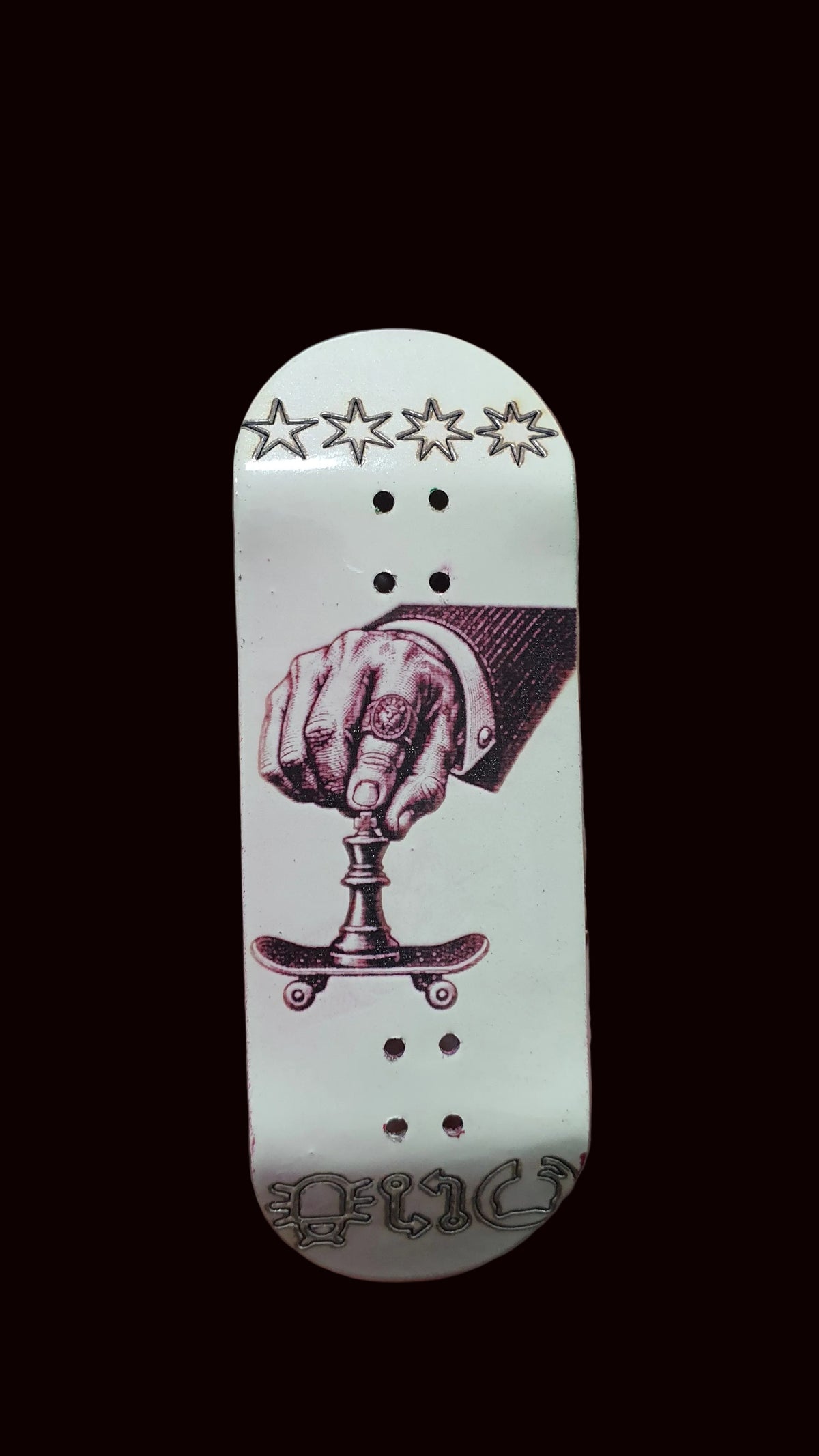 White fingerboard deck with purple boxing-hand artwork, stars at top, and dot holes
