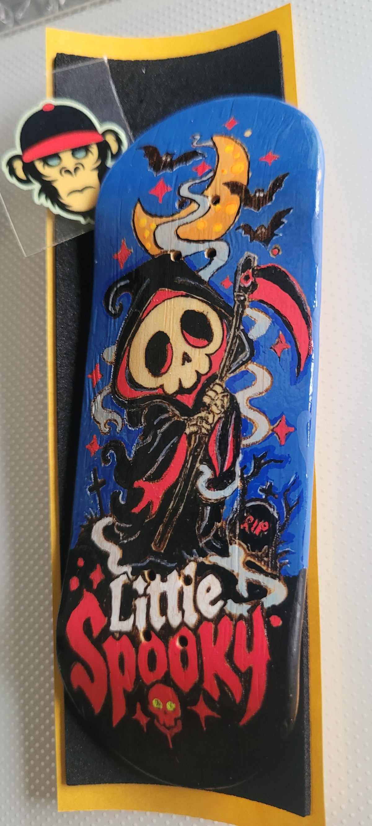 Blue fingerboard deck featuring witch skull artwork and red "Little Spooky" title