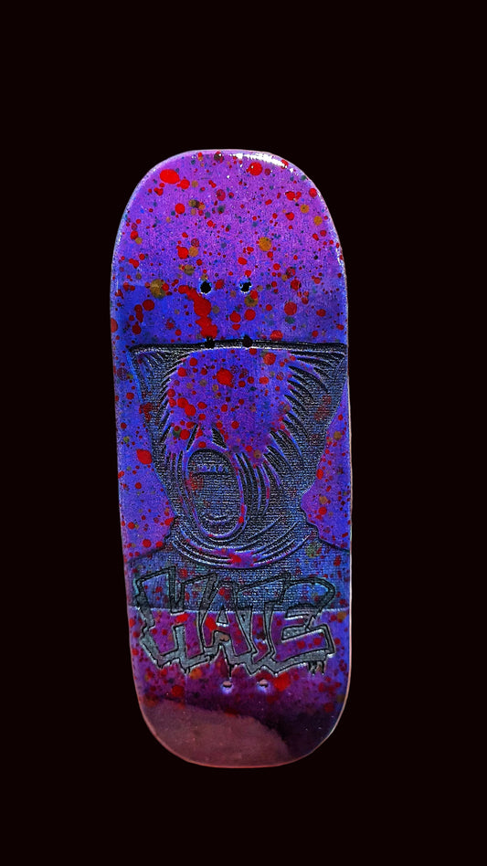 Purple fingerboard deck with animal face illustration and 'HATE' lettering on bottom half.