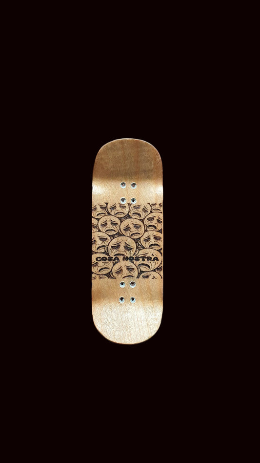 Gold fingerboard deck with line-art faces and rivet dot details on top