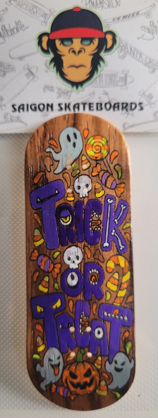 Skateboard deck with orange Halloween graphic: Trick or Treat, ghosts and pumpkin