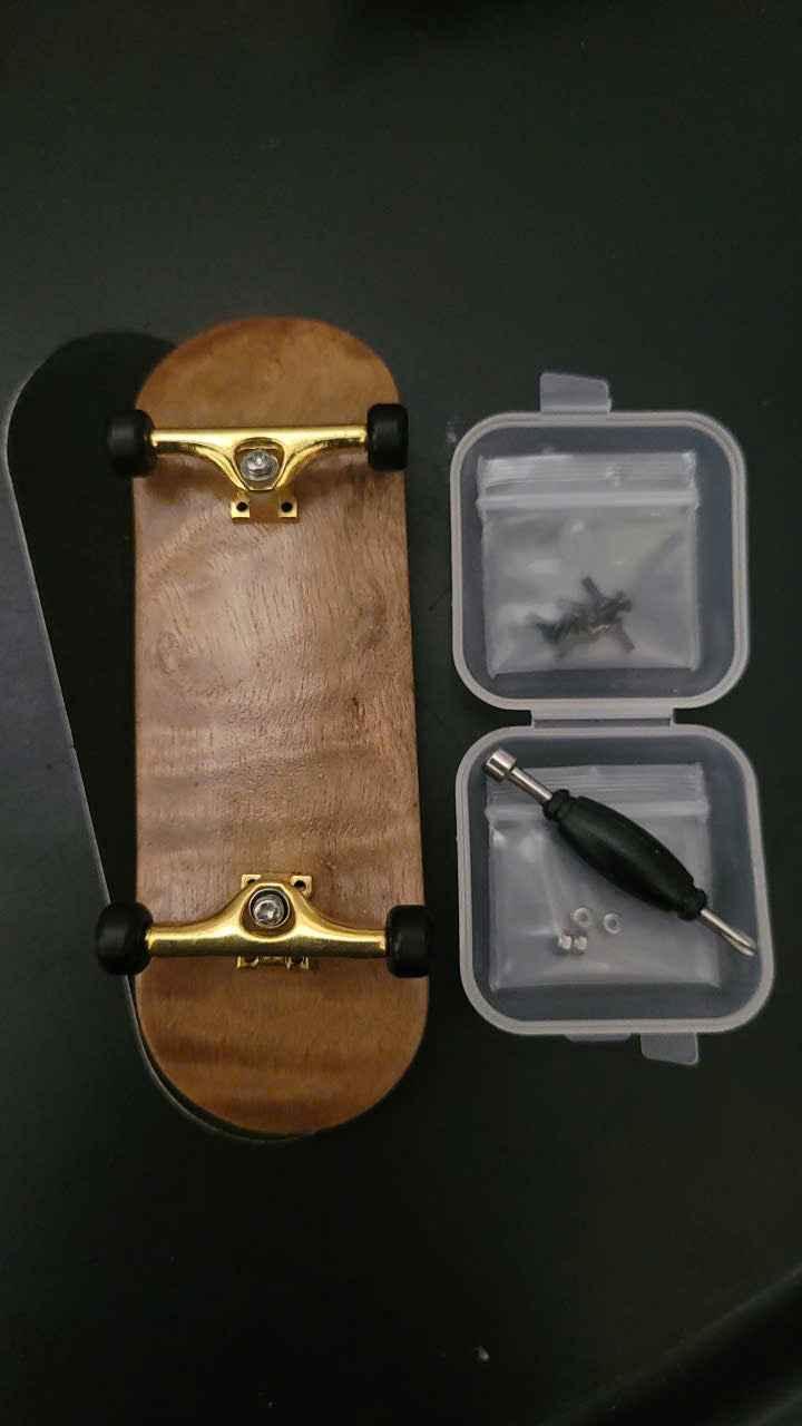 Custom wooden fingerboard with gold trucks and black wheels with accessories in a small case.