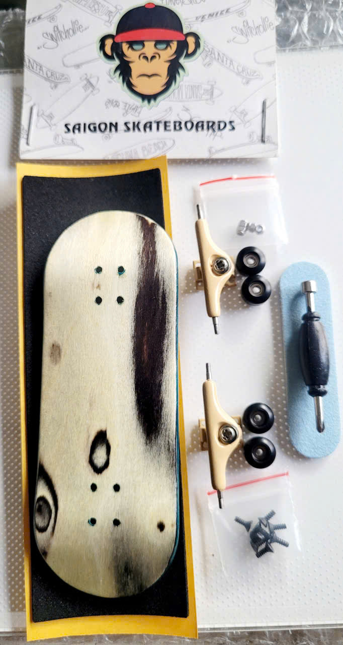 Fingerboard set with natural wood-grain deck, beige trucks, wheels, tool, and hardware