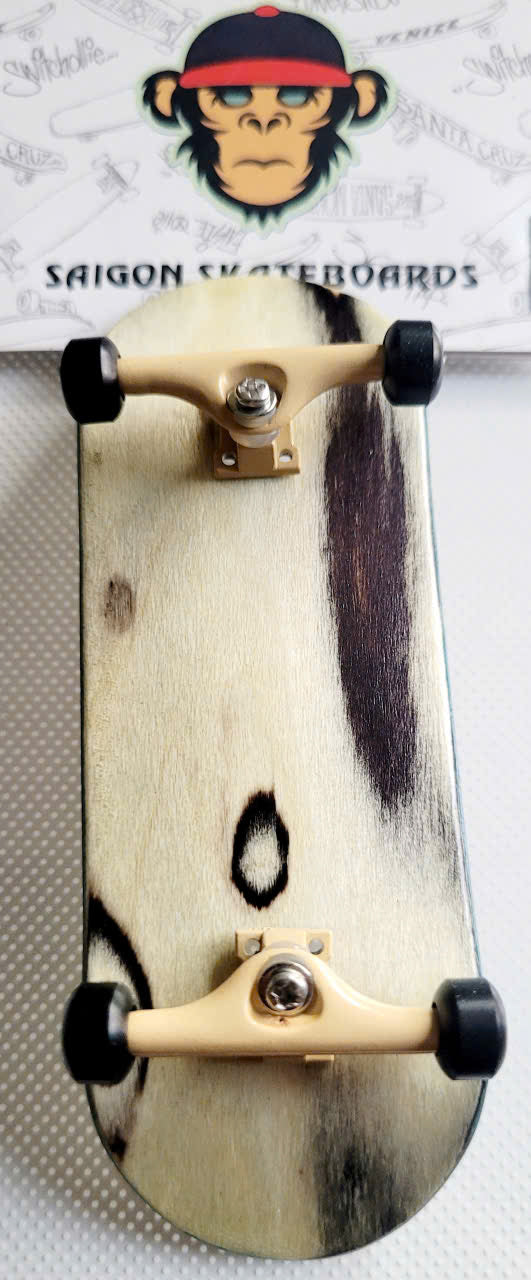 Fingerboard with natural wood-grain deck, beige trucks, and black wheels