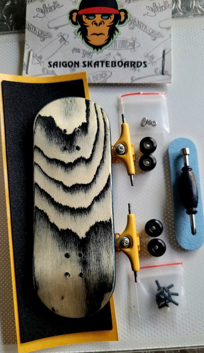 Fingerboard set with wavy black-and-cream deck, yellow trucks, wheels, tool, and hardware